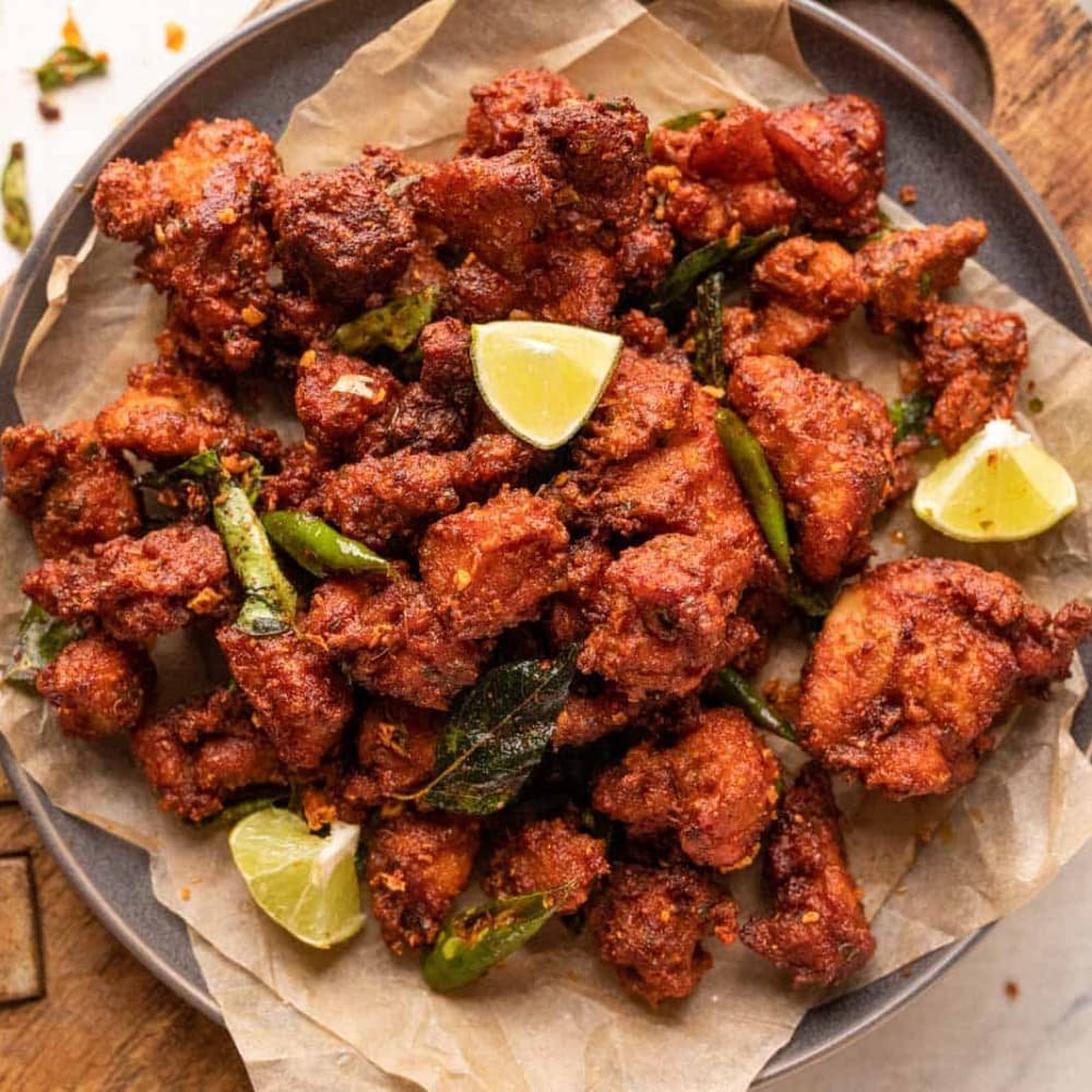 Chicken 65, boneless chicken pakoras tossed with curry leaves and green chillies
