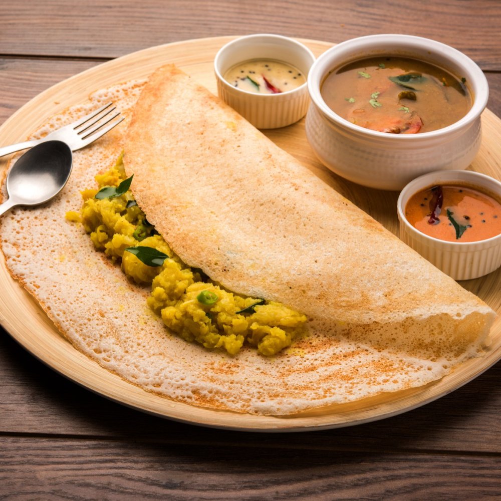 Masala dosa with spiced potato filling, served with sambar and two chutneys